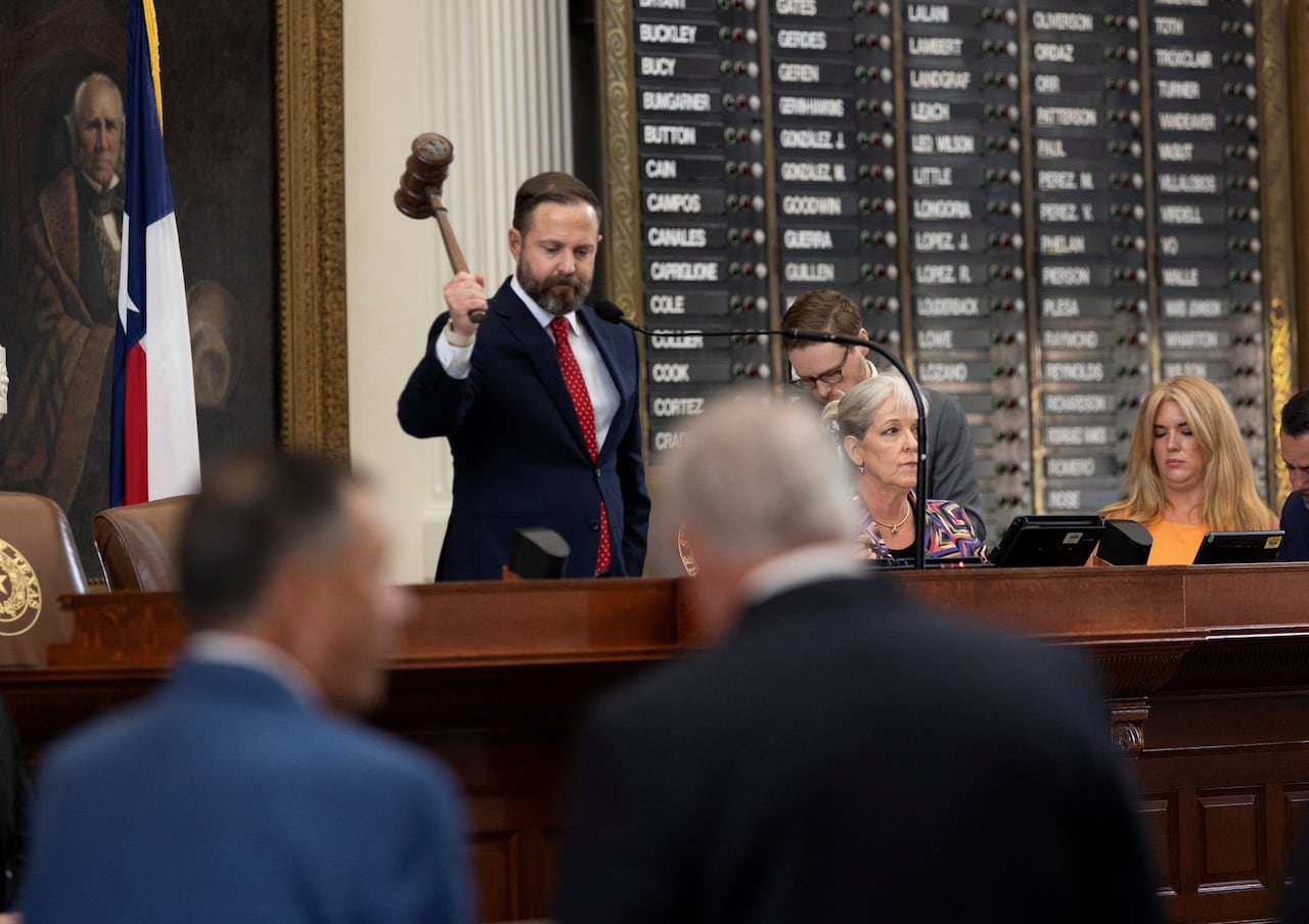 A person standing at a panel bangs a gavel.