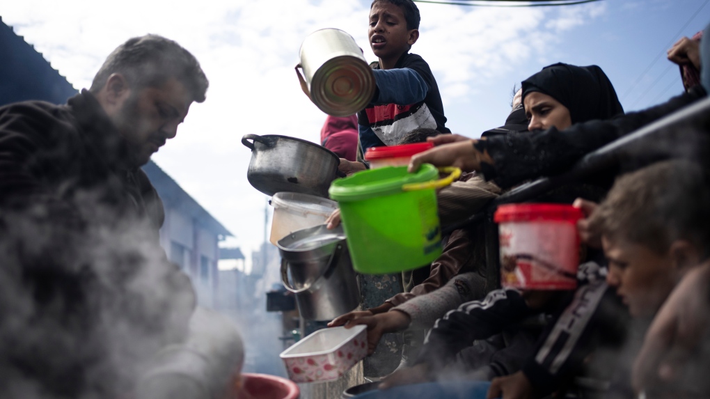 2024 年 2 月 16 日星期五，巴勒斯坦人在加沙地带拉法排队吃饭。（美联社照片/Fatima Shbair） 