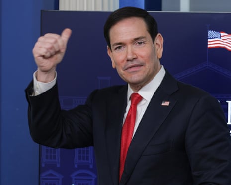 a man in a suit gives a thumbs up