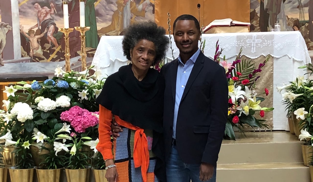 A man and woman stand in a church and pose for a photo.