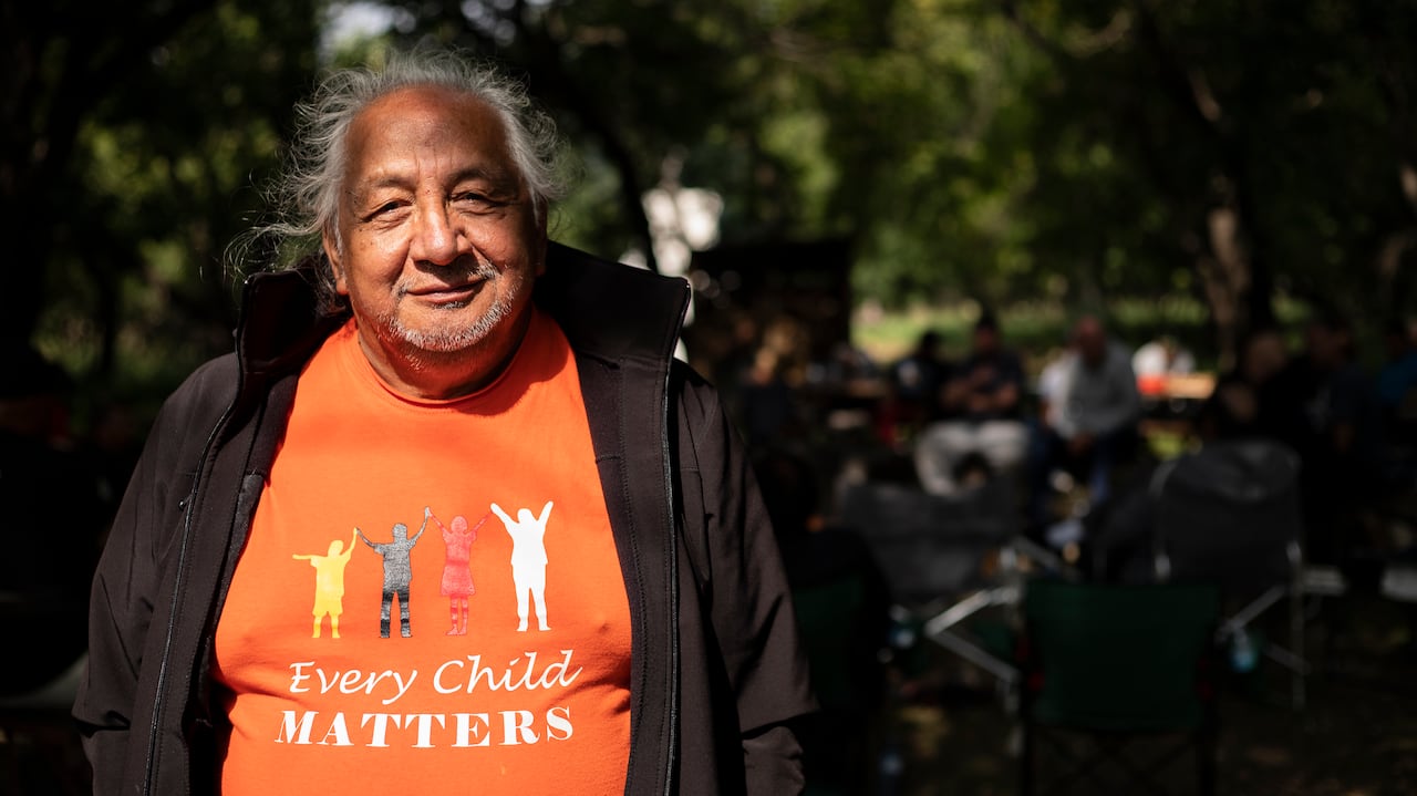 A man smiles wearing an every child matters t-shirt.