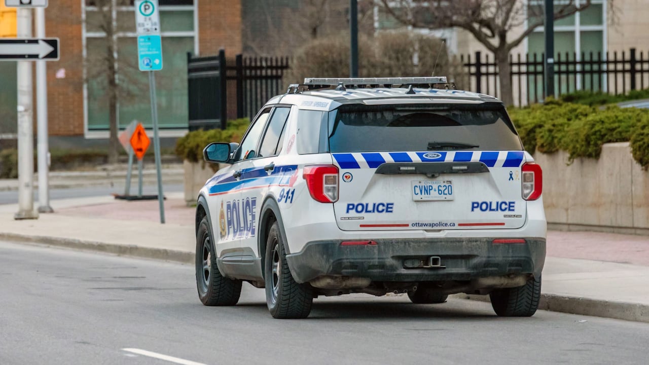 A police cruiser driving on a city street.