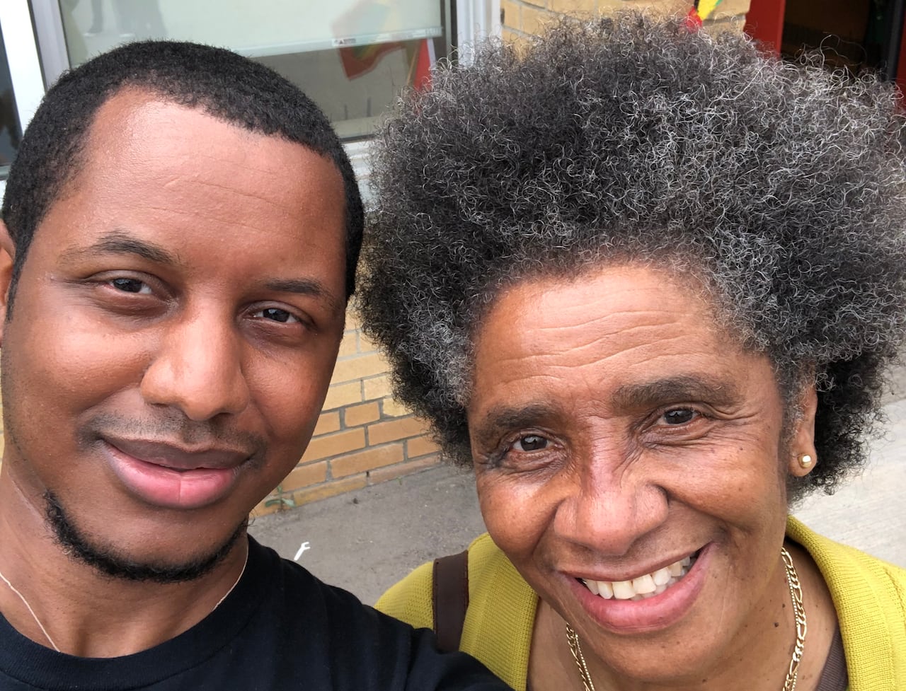 A black man and a black woman smile in a selfie.
