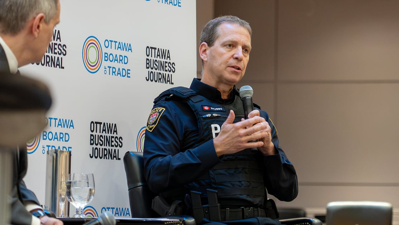A man in uniform holds a microphone.