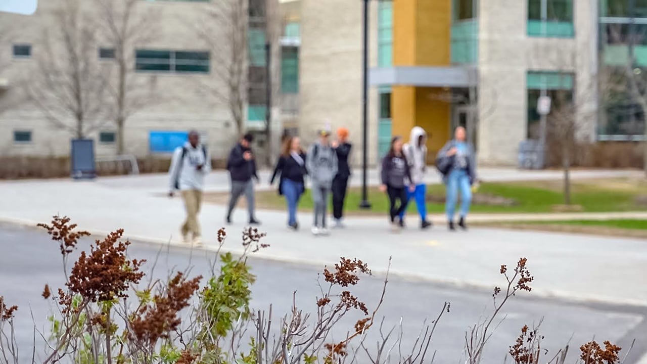 Students walking outside near buildings.