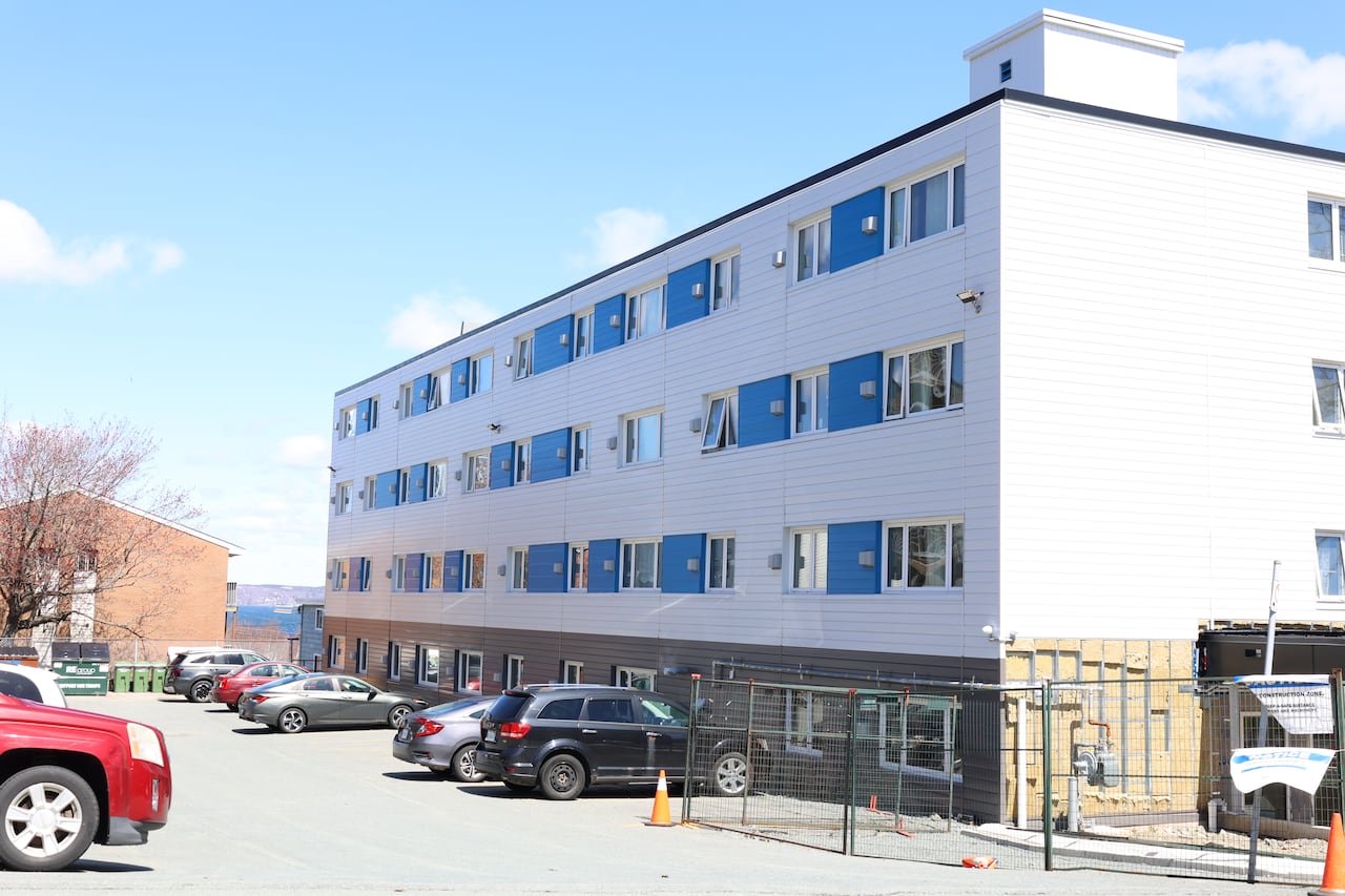 A newly renovated non-profit apartment building is seen next to a parking lot.