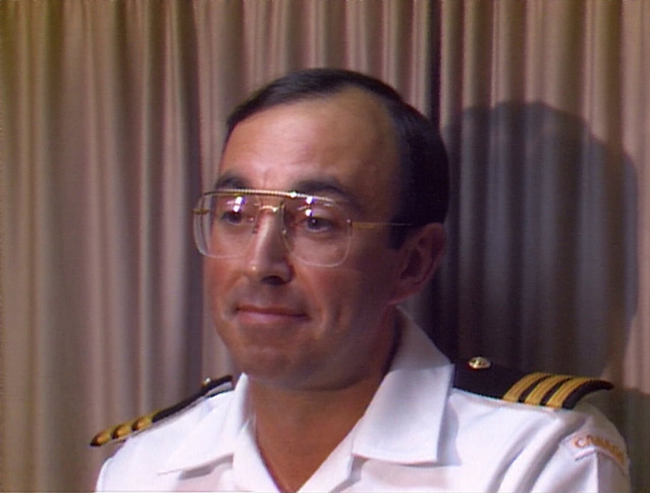 An archival photo shows a Canadian navy captain smiling at a press conference.