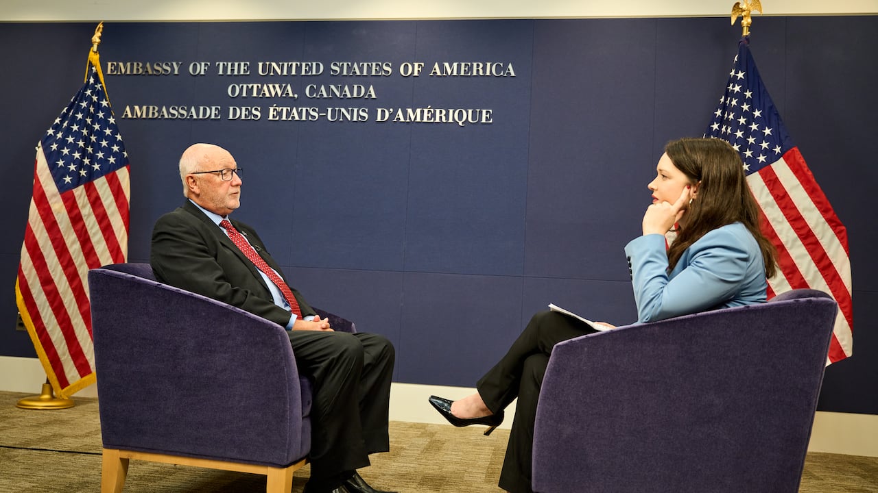 A man and woman sitting in chairs facing each other.