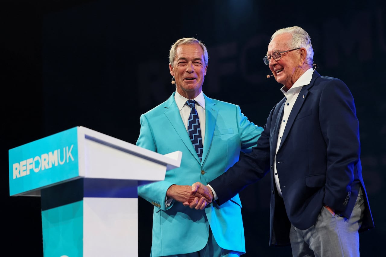 Britain's Reform UK party leader Nigel Farage shakes hands with Preston Manning as they share the stage during the party's national conference at the National Exhibition Centre in Birmingham, Britain, September 5, 2025.