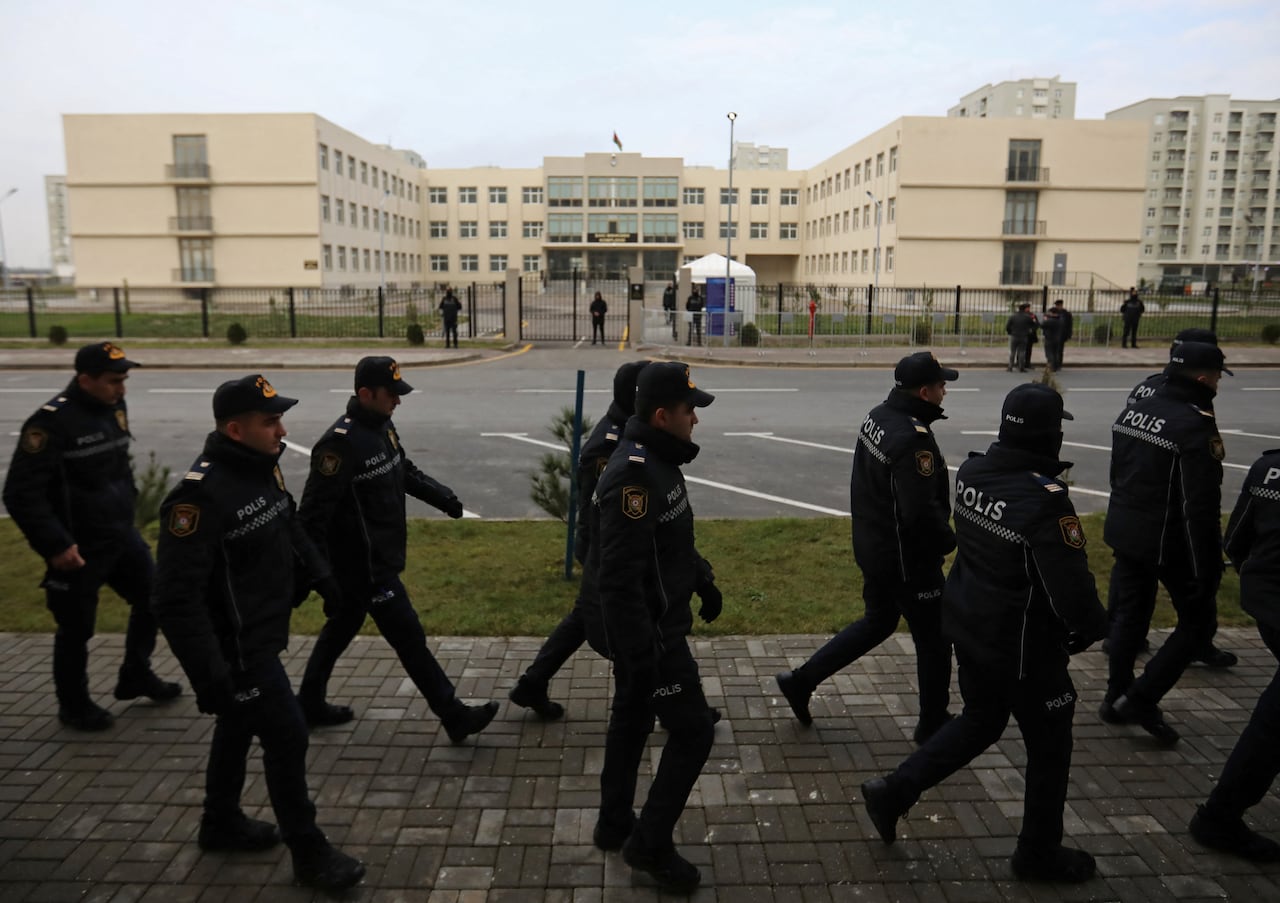 Soldiers marching in front of a courthouse.
