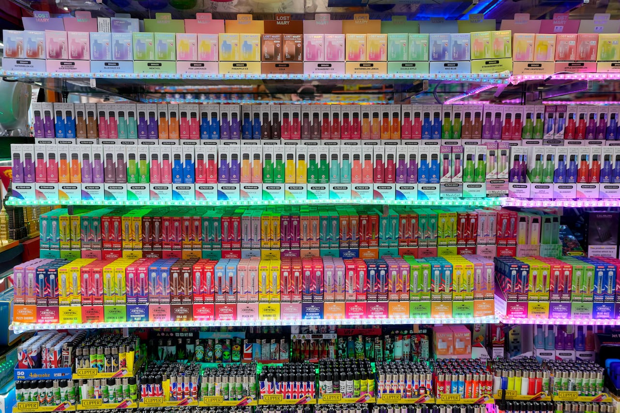 Various vape flavours are displayed in a shop.