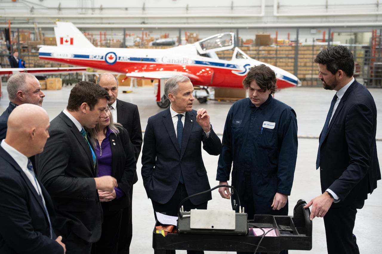 Prime Minister Mark Carney speaks with a avionics technician while touring IMP Aerospace in Halifax, on Thursday, March 26, 2026. THE