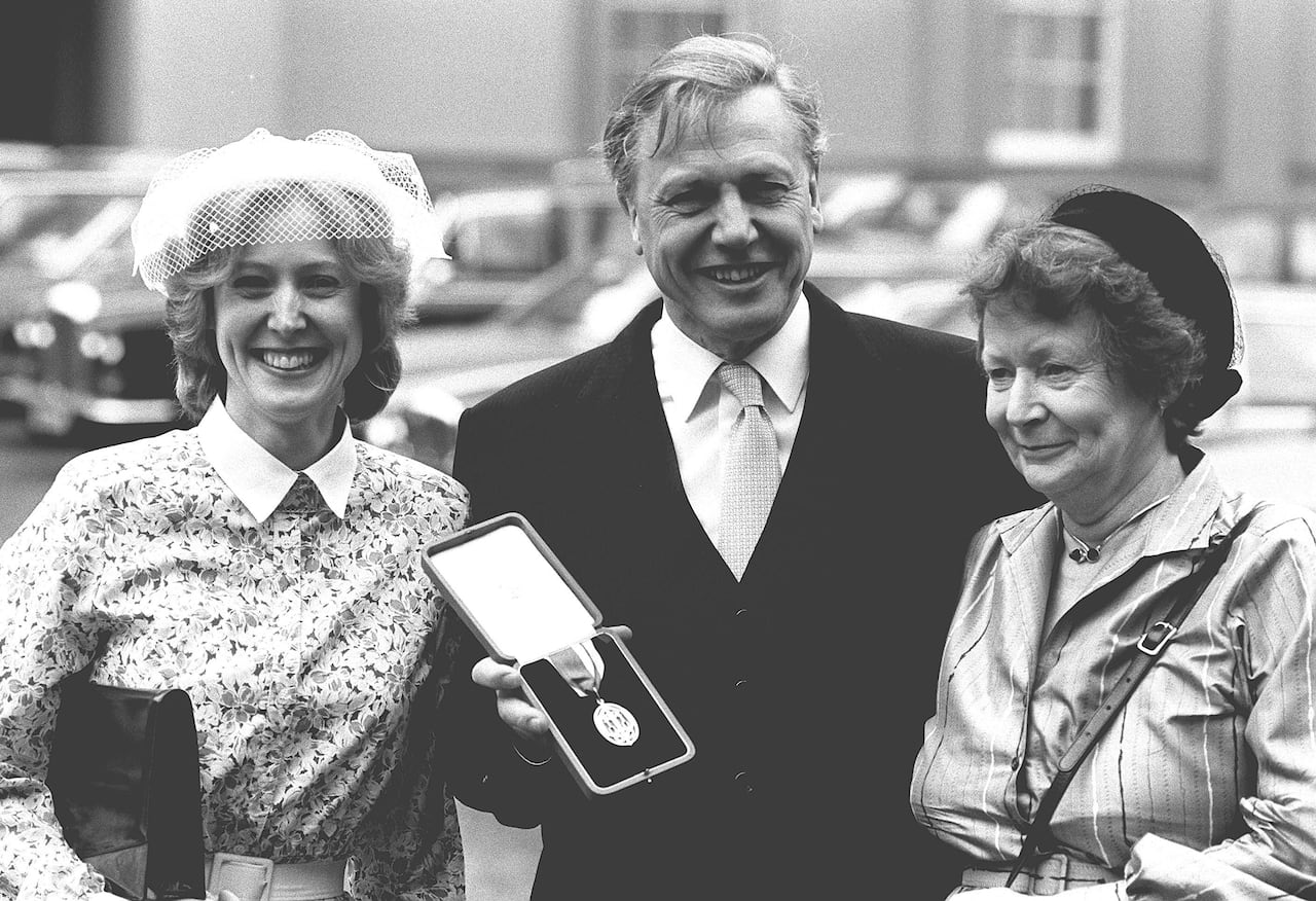 David Attenborough poses for a photo with his wife Jane, right, and daughter Susan after being knighted by the queen