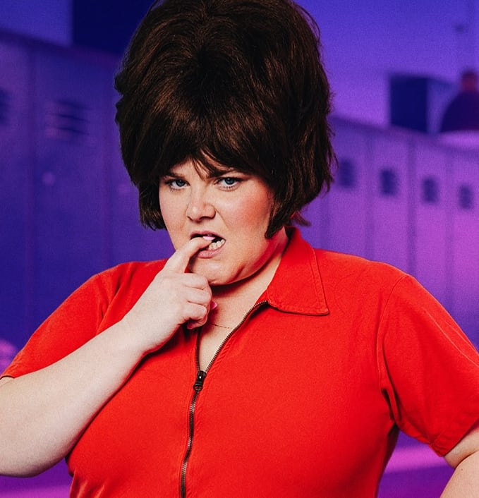 Woman wearing red with big beehive hair posing for the camera.