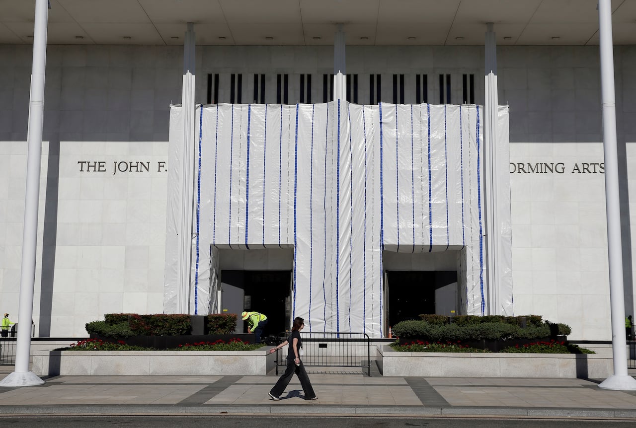 A building with a large white tarp across the entrance is shown.