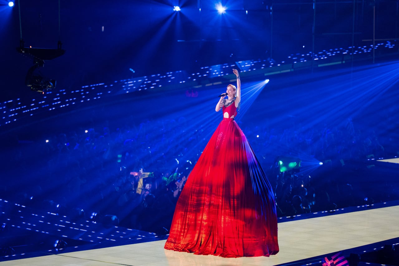 Woman in large red dress performing onstage.