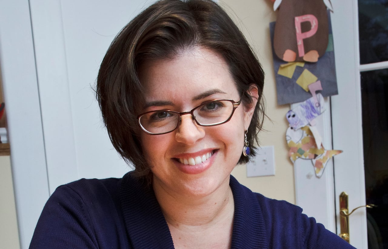 Woman with glasses smiles for the camera.