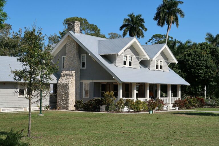 A grey house with a stone chimney and porch in Fort Myers, Florida