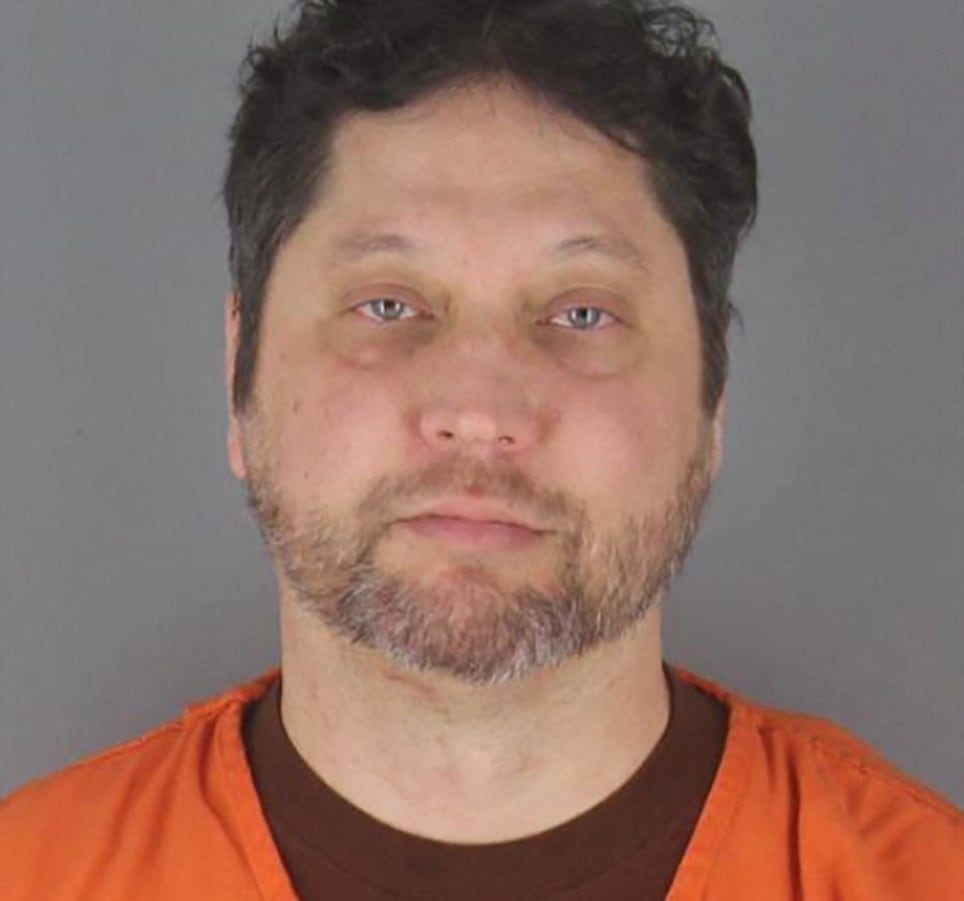 Mug shot of brown haired man in orange jumpsuit