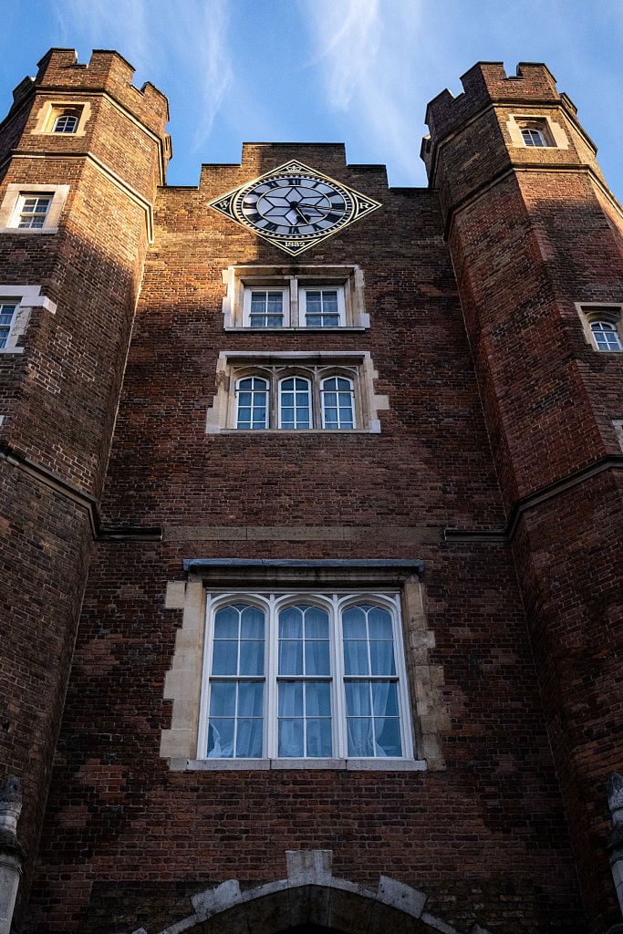 An exterior shot of large brick building with arched windows and a clock on it.