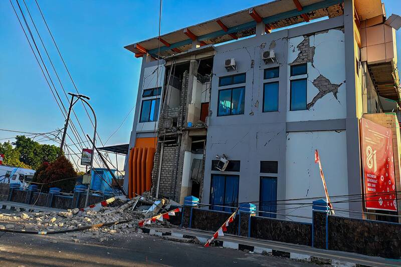 印尼東努沙登加拉省（East Nusa Tenggara）倫滕（Ruteng）一棟建築在強震後嚴重受損，外牆出現大片裂縫，部分樓層結構坍塌。（法新社）