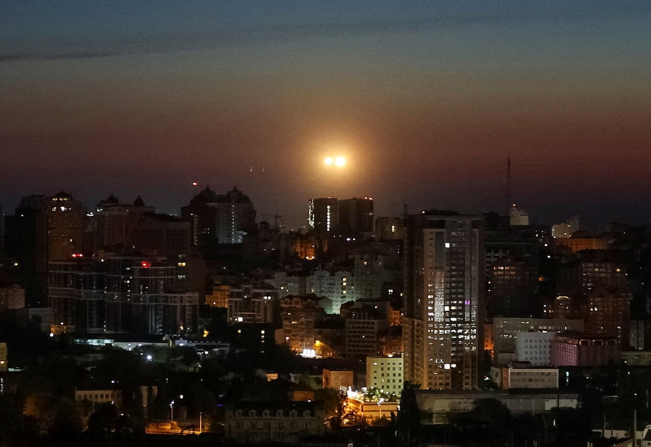 A view of the skyline of Kyiv, Ukraine, with explosions seen occurring over the city as Ukrainian soldiers fire on a Russian drone.