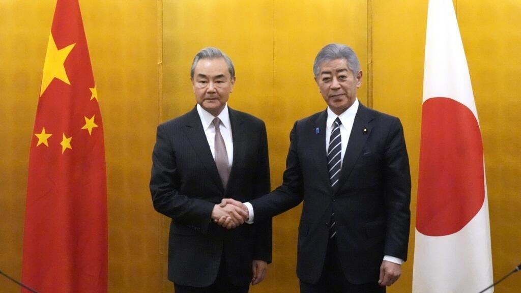 2025年3月22日星期六，日本外务大臣岩屋毅（右）在东京与中国外长王毅（左）会晤前握手。（美联社照片/尤金·星子，联合供图）