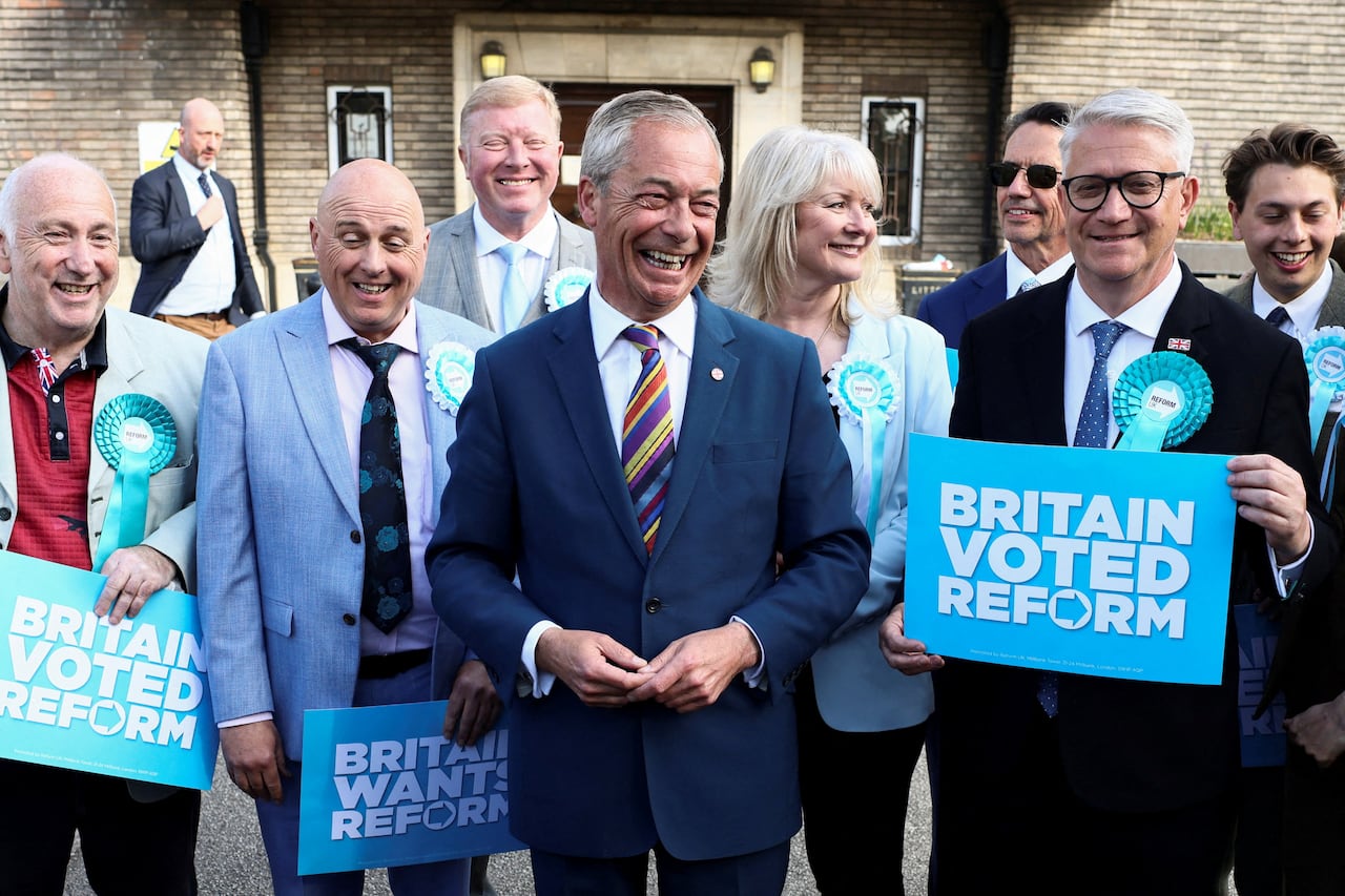 Britain's Reform UK leader Nigel Farage reacts next to newly elected councillors and Member of Parliament, Andrew Rosindell at the Havering Town Hall, following the results of the local elections, in the London Borough of Havering, Britai