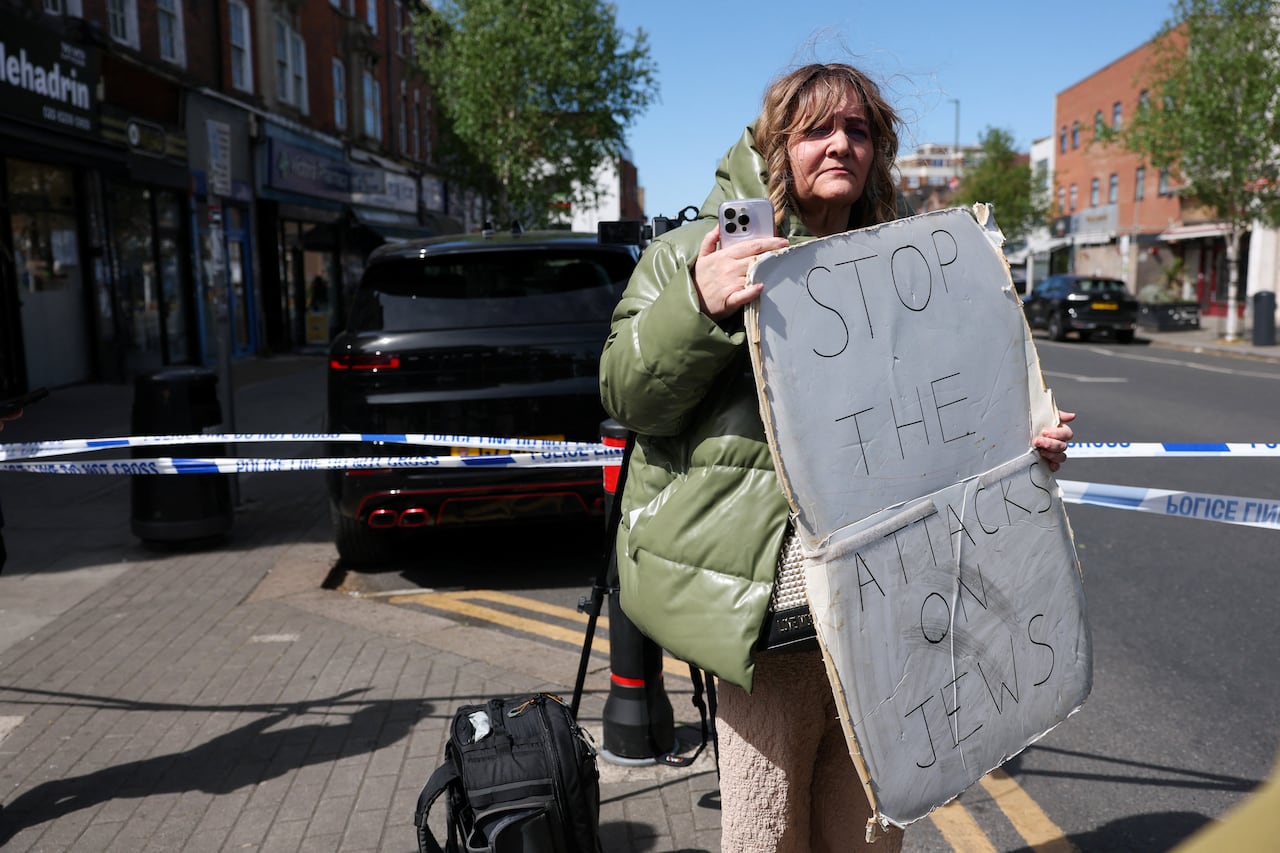 A demonstrator holds a sign that reads "Stop the attacks on Jews."