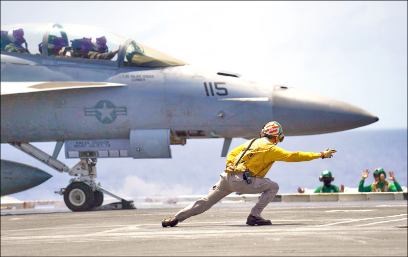 羅斯福號上的甲板彈射官向F/A-18戰機飛行員下達彈射起飛命令。（法新社）