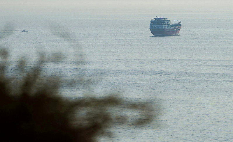 从阿曼望向荷莫兹海峡，一艘船只正通过。(路透)