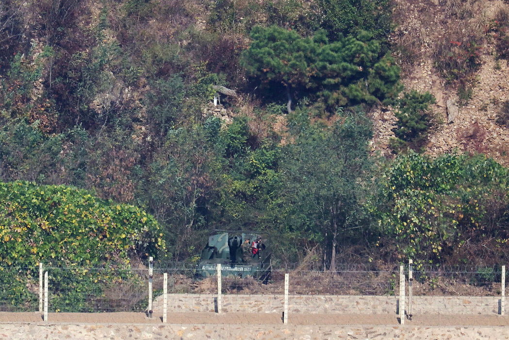 南韓金浦市一處觀景台27日可望見北韓士兵在部署於兩韓邊境的122公厘自走榴彈砲旁...