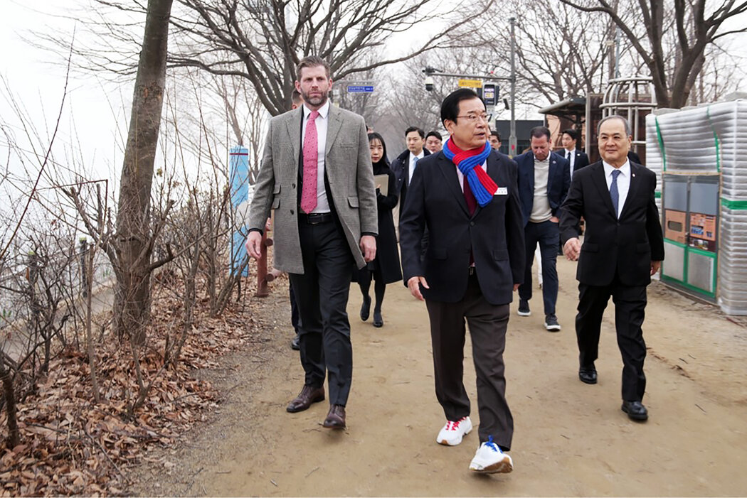汉南市政府发布的一张照片显示，埃里克·特朗普（左）于2月访问韩国汉南市，他身边是基地集团董事长金成集（右）和市长李贤宰（中）。