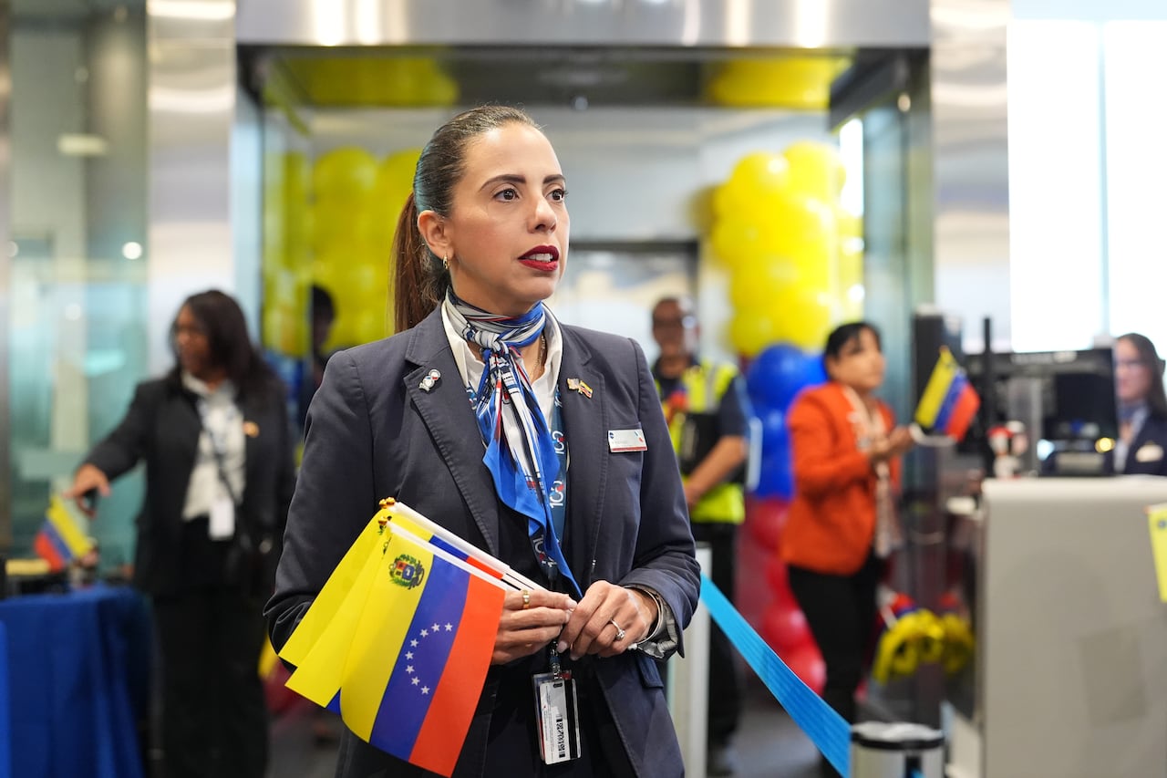 An American Airlines employee holds a set of small-format Venezuelan flags