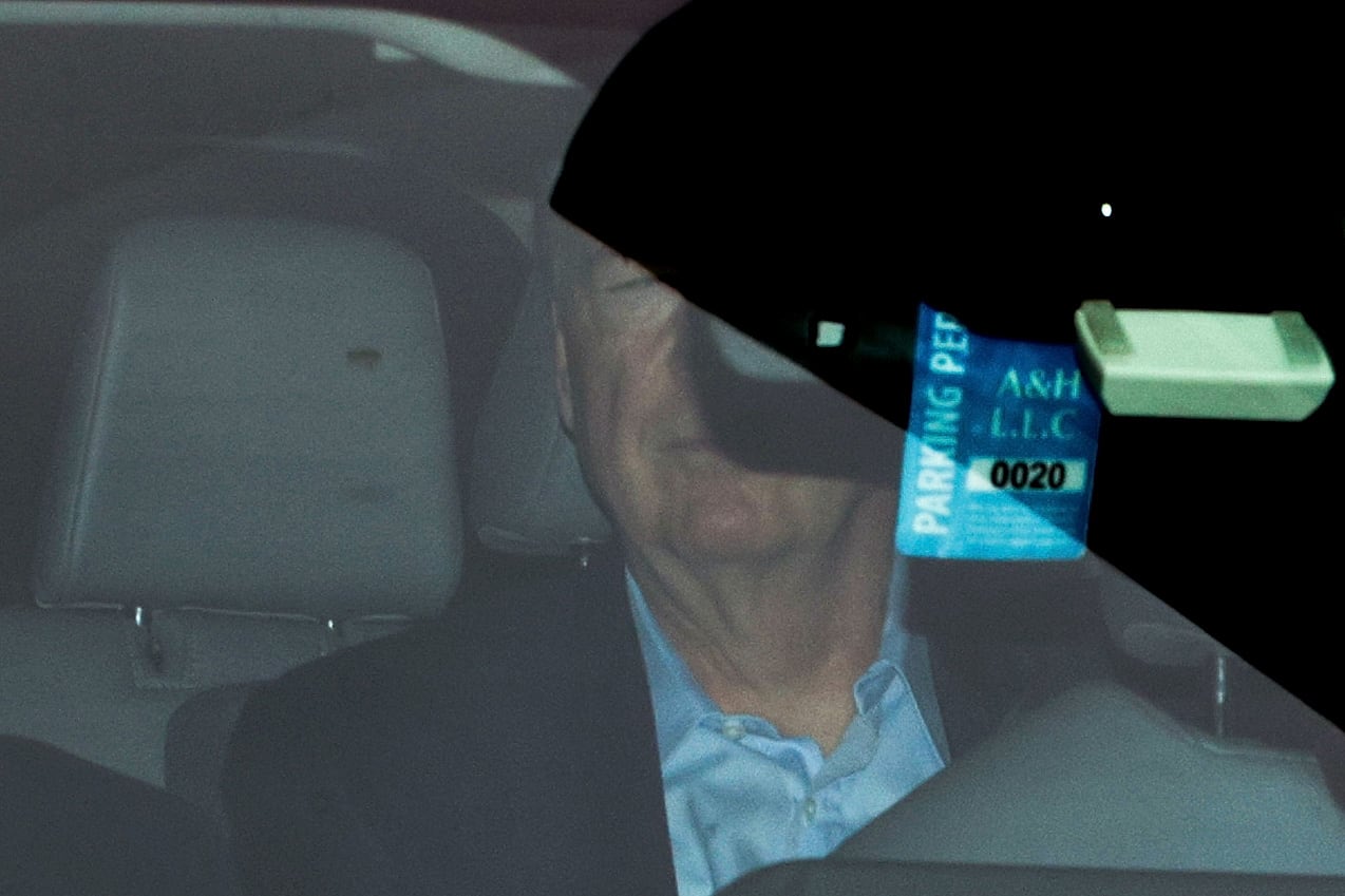 Man in blue shirt seen through a car window