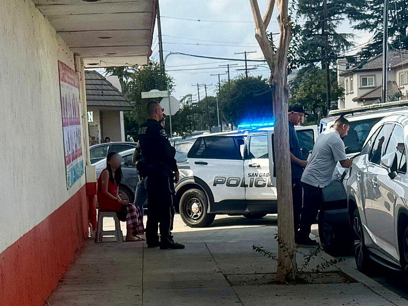 一名仍穿著睡衣的長髮女在警察的盤問下掩面痛哭。圖片經過馬賽克處理。（記者王若然／...