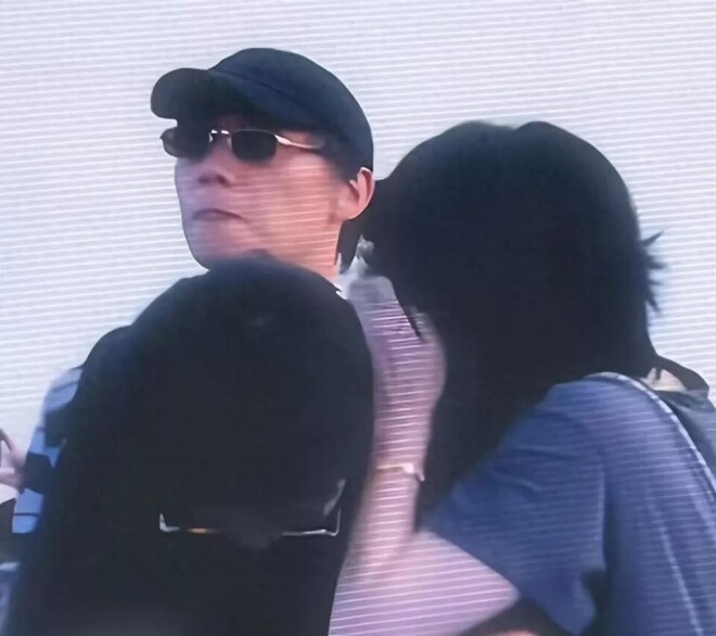 王菲躲镜头扑进黑衣男怀里 是陪了她16年的男人（配图1）
