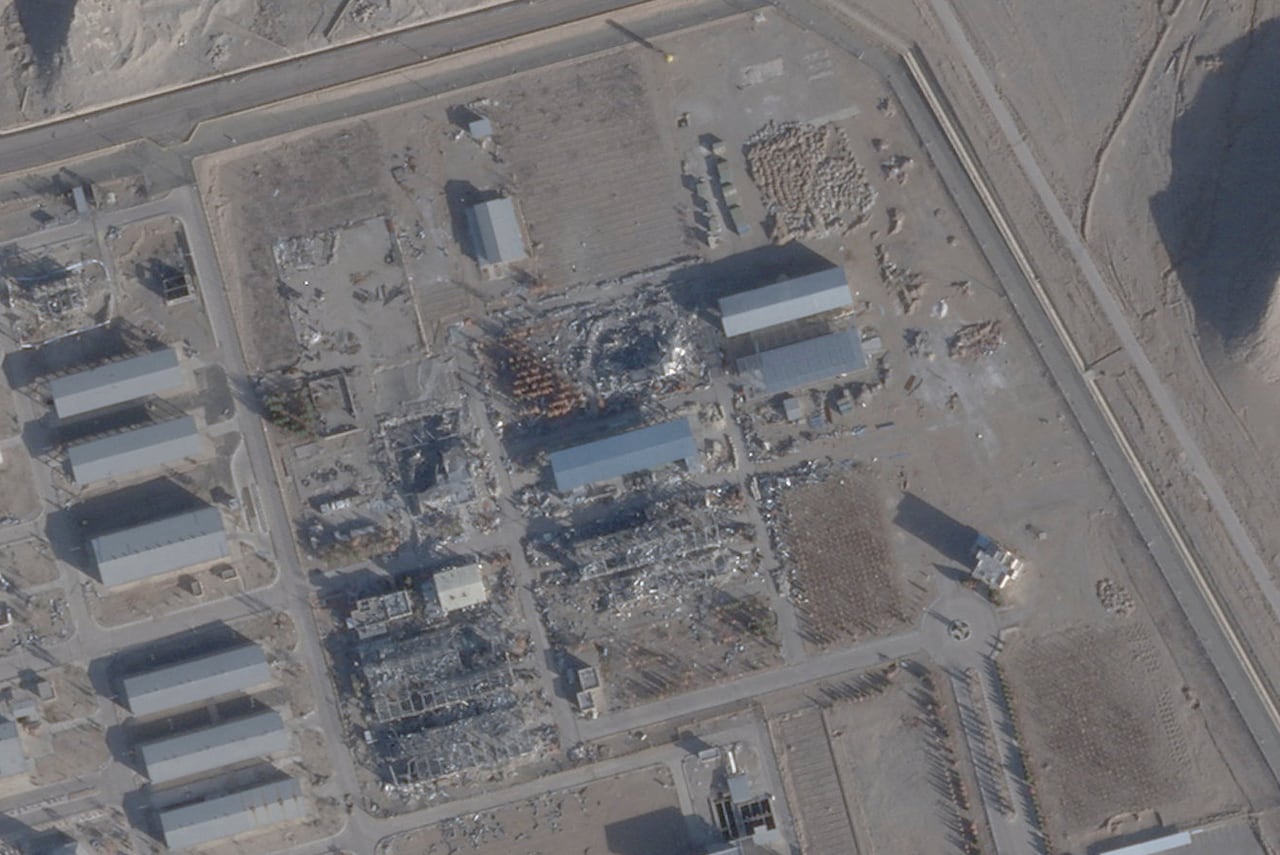 A satellite photo gives an overhead look at a series of buildings, with damage shown at some locations on the plot of land.