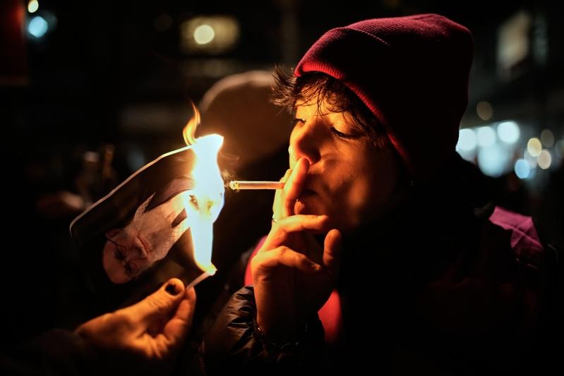 2026年1月14日，在德国柏林的声援伊朗抗议活动中，一名抗议者点烟燃烧伊朗最高...