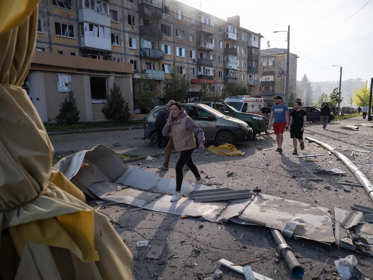 People walk through rubble