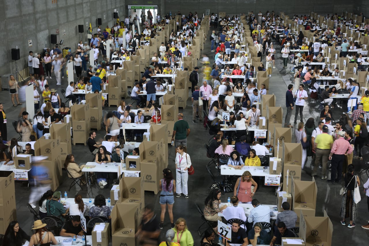 An elevated view shows rows of voters casting ballots in booths.