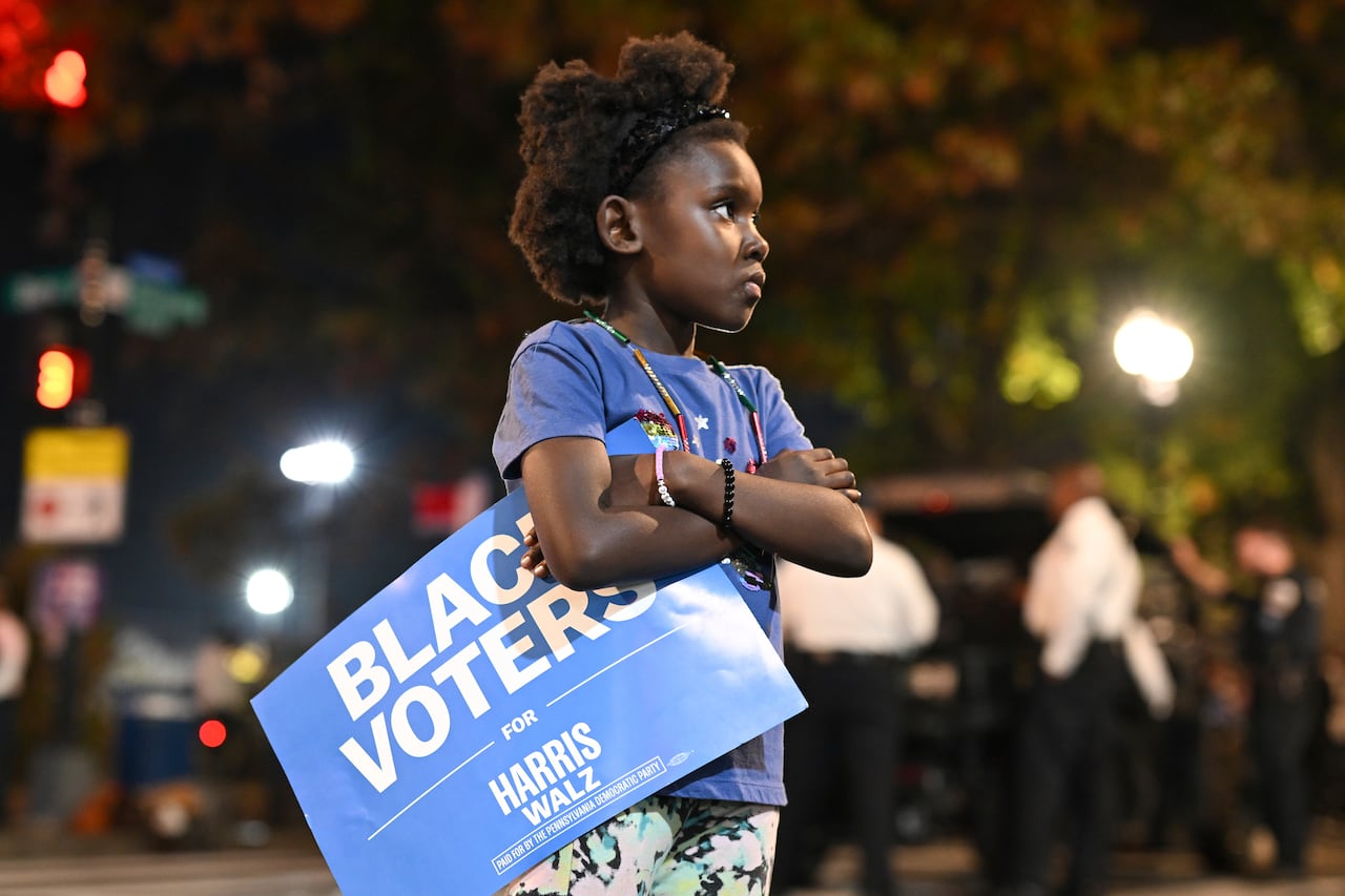 A young girl holds a "Black Voters for Harris-Walz" sign outside of Democratic presidential nominee Vice President Kamala Harris' election night watch party at Howard University, Tuesday, Nov. 5, 2024, in Washington.