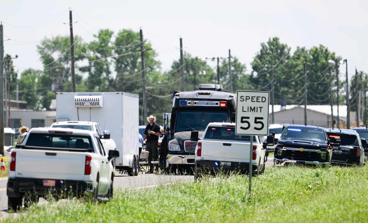 Emergency vehicles are seen parked on a road.