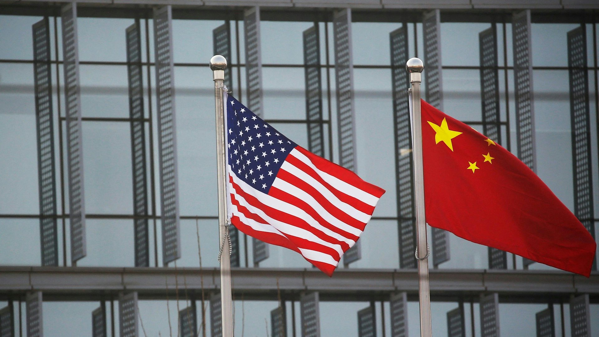 2021年1月21日，中國北京一間美國企業大樓外有中美兩國國旗隨風飄揚。（Reuters）