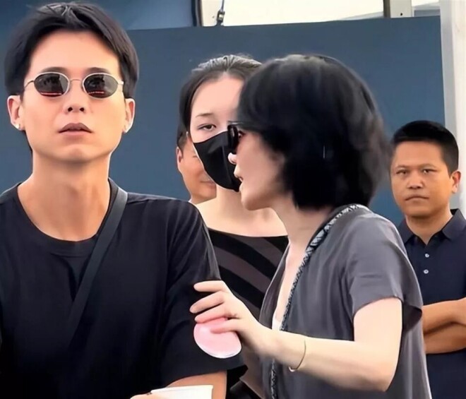 王菲躲镜头扑进黑衣男怀里 是陪了她16年的男人（配图11）
