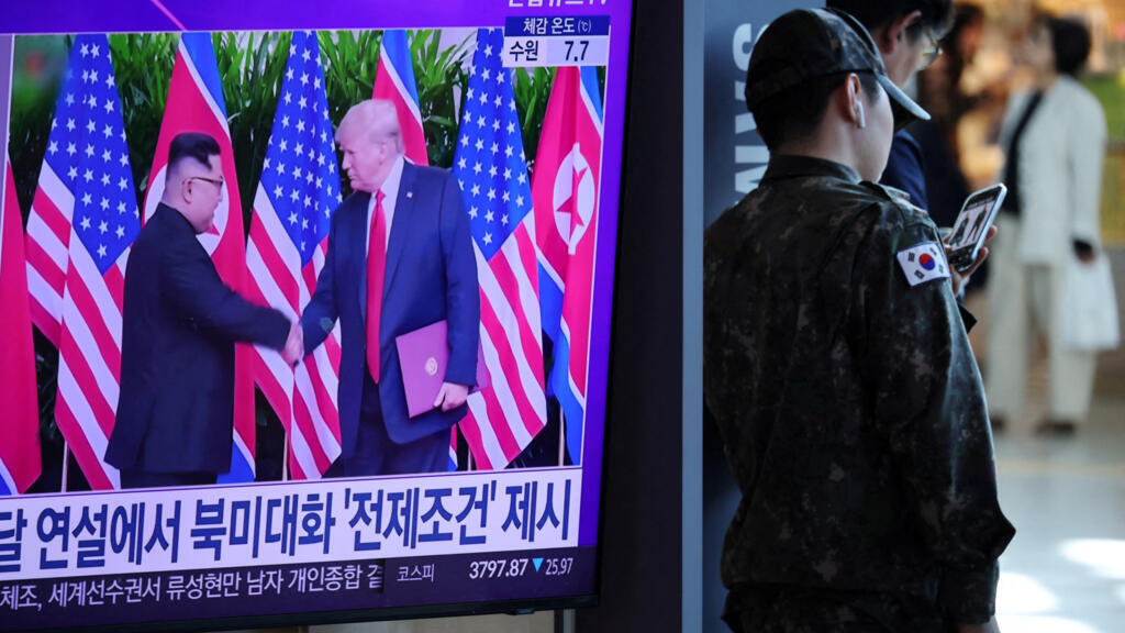 2025年10月22日，在韩国首尔的一处火车站，一名韩国士兵站在一台正在播放有关朝鲜领导人金正恩与美国总统特朗普可能举行峰会的新闻报道的电视机旁。