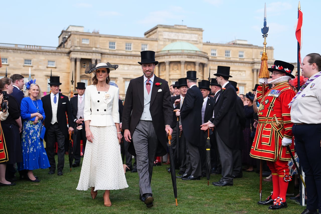 Two people on a lawn in front of a crowd.
