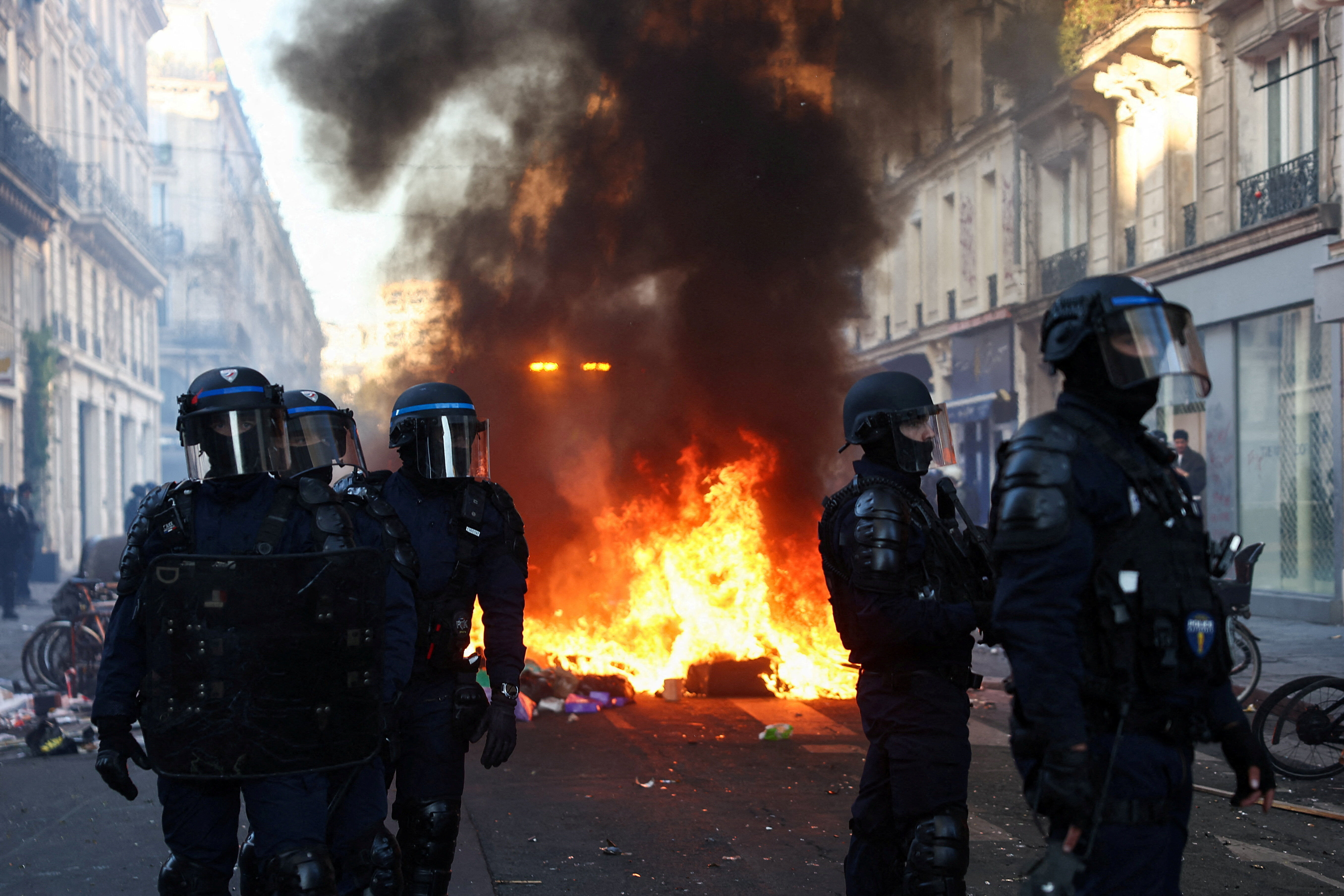 ▲ 法国爆发反生活成本与燃料价格飙涨抗议，巴黎街头燃起烈火，镇暴警察在旁戒备。（图／路透）