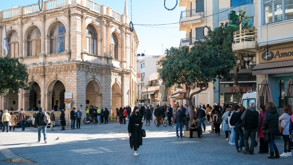 2021 年 2 月 24 日星期三，人们在希腊克里特岛哈尼亚市政厅外排队，进行 COVID-19 快速检测。（美联社照片/Harry Nakos）