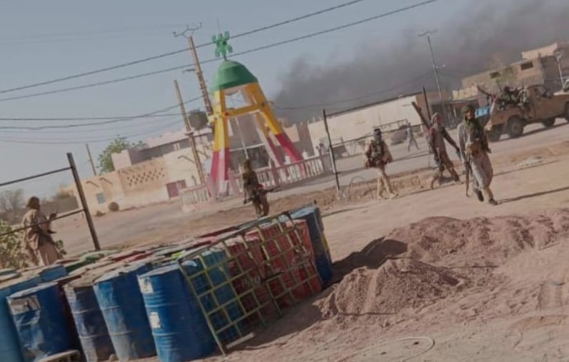 Armed militants walk on a street.
